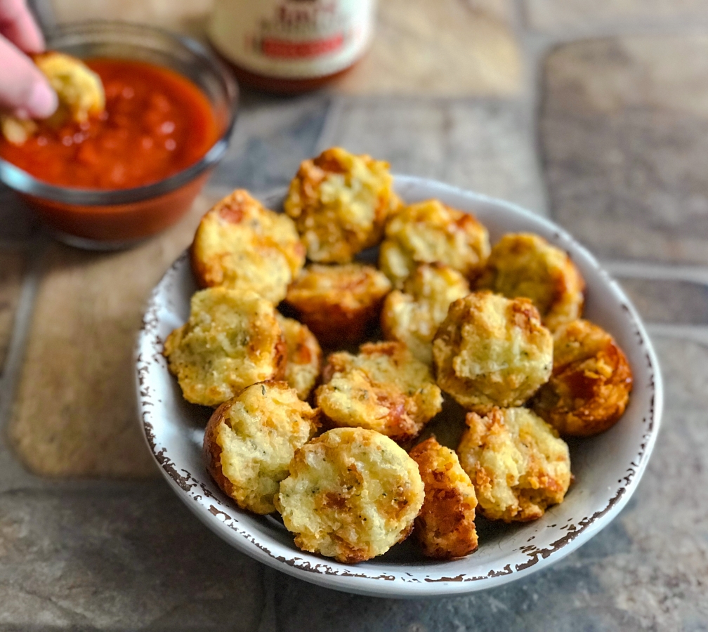 bowl of pizza muffin bites with pizza sauce on the side