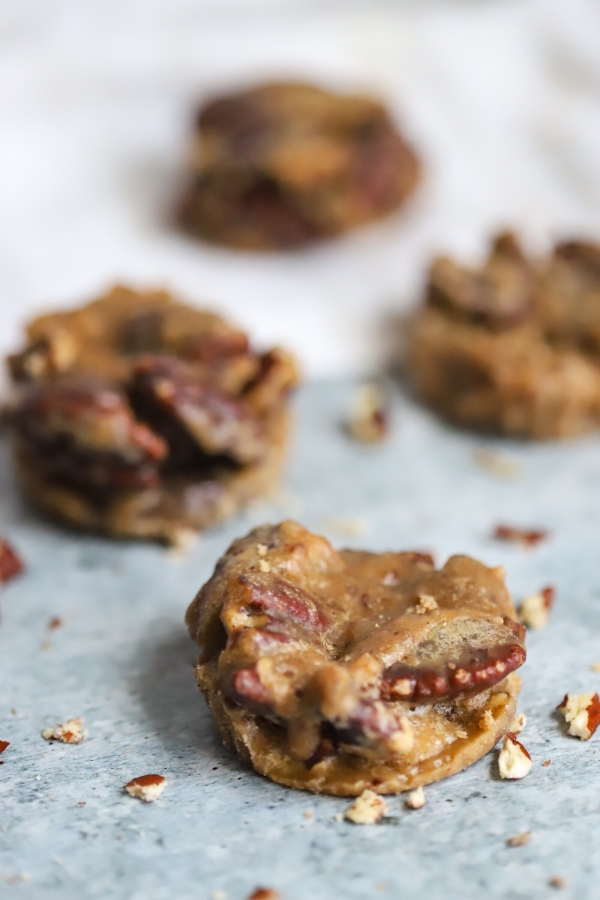 one pecan praline in the front with three other blurred in the background