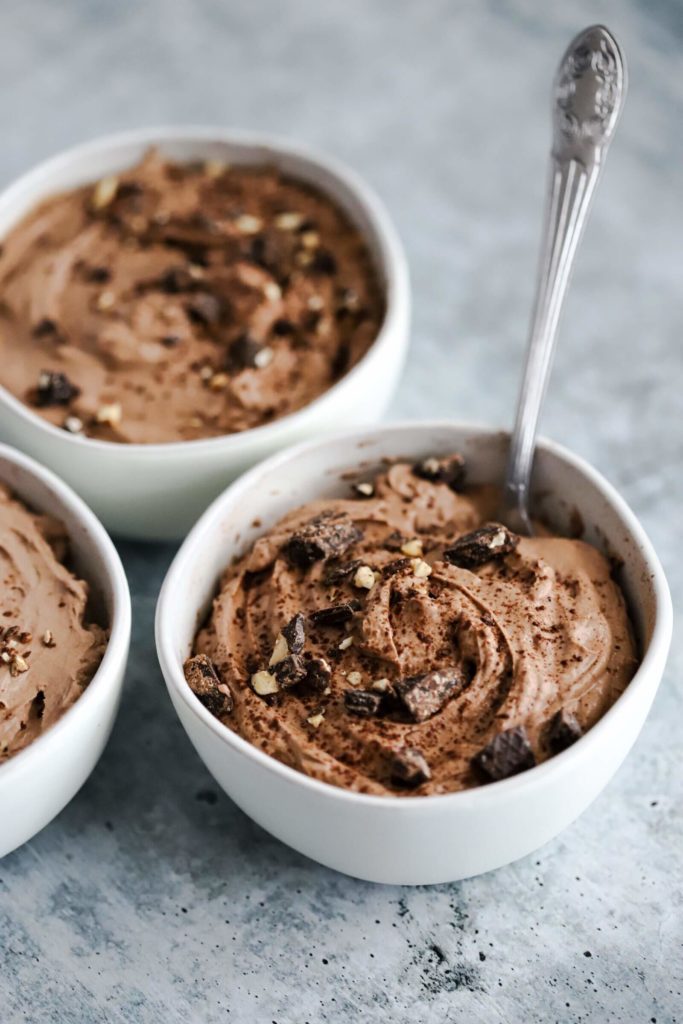 a bowl of chocolate keto pudding with a spoon in it 