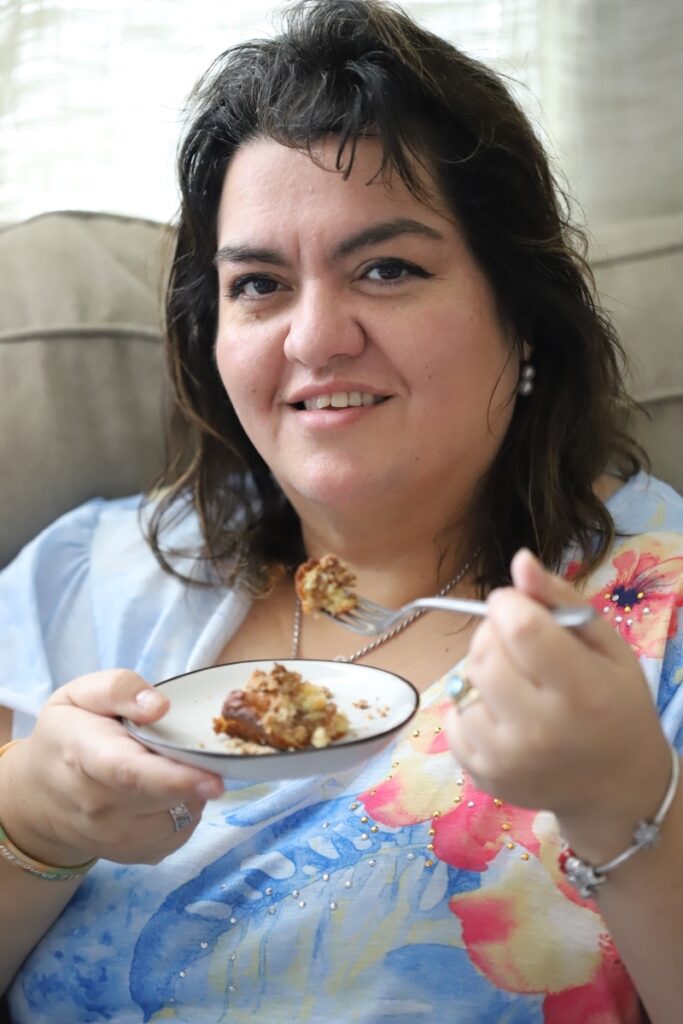 photo of my mom eating a piece a piece of coffee cake with a fork held up to her mouth