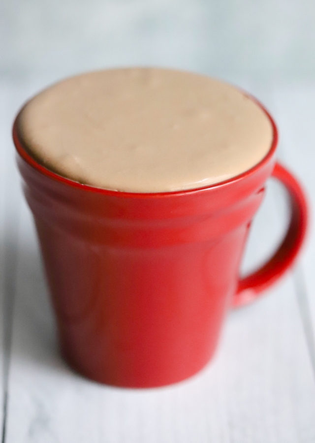 red mug with keto chocolate frosty hovered the top of the mug