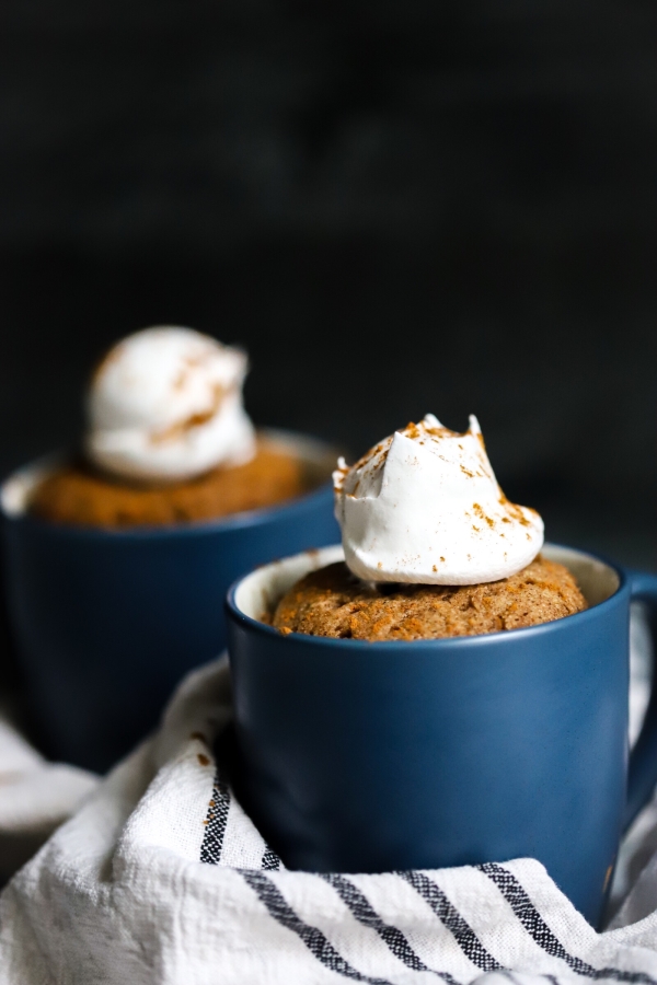 two pumpkin spice mug cakes with one in front of the other. 