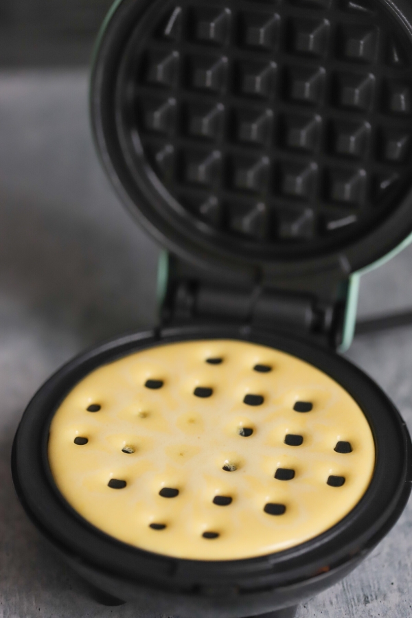 batter added to the waffle maker griddle
