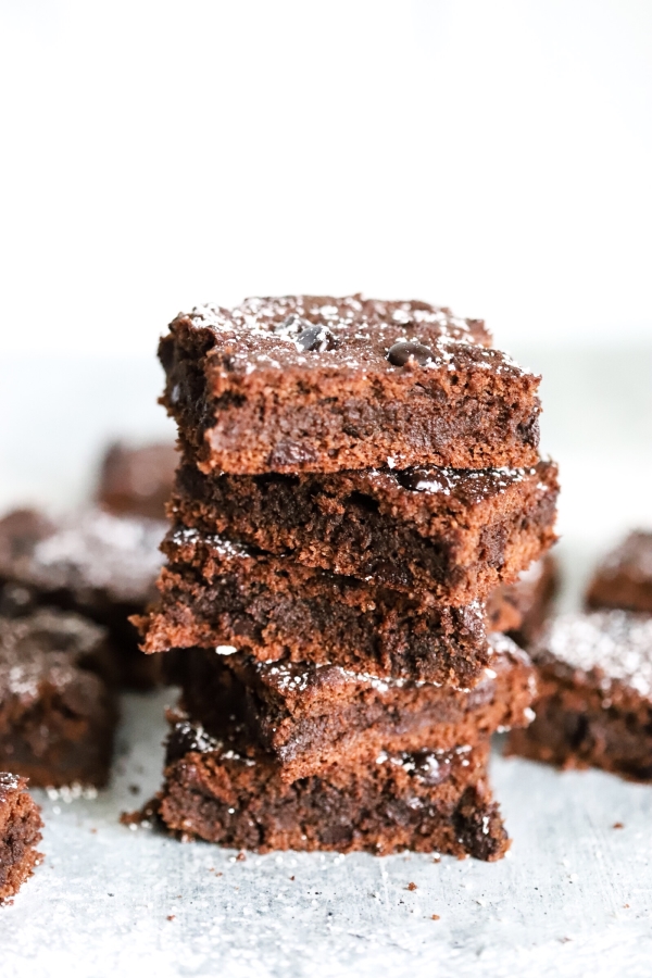 Stack of five keto brownies in the center with a few in the background