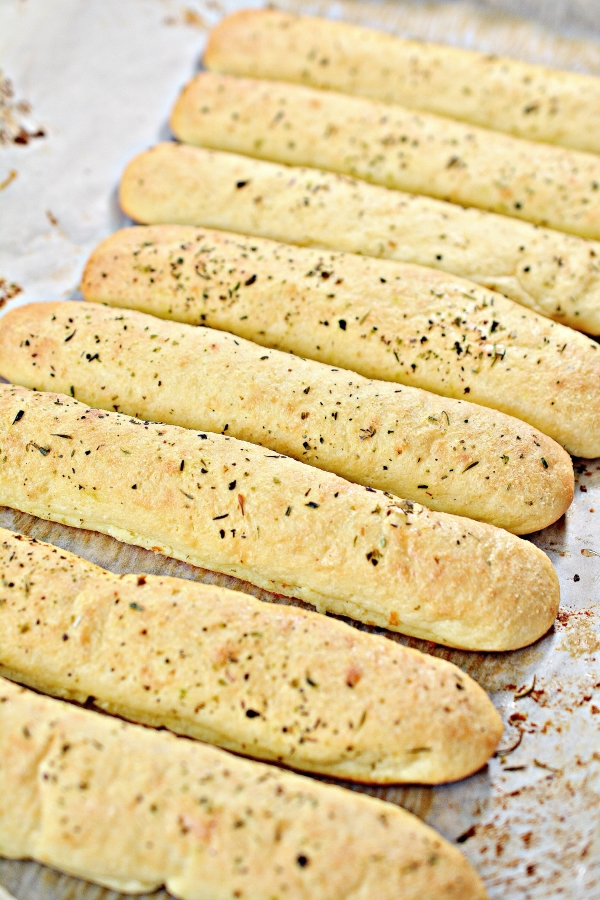 keto breadsticks lined up in a baking pan close to each other