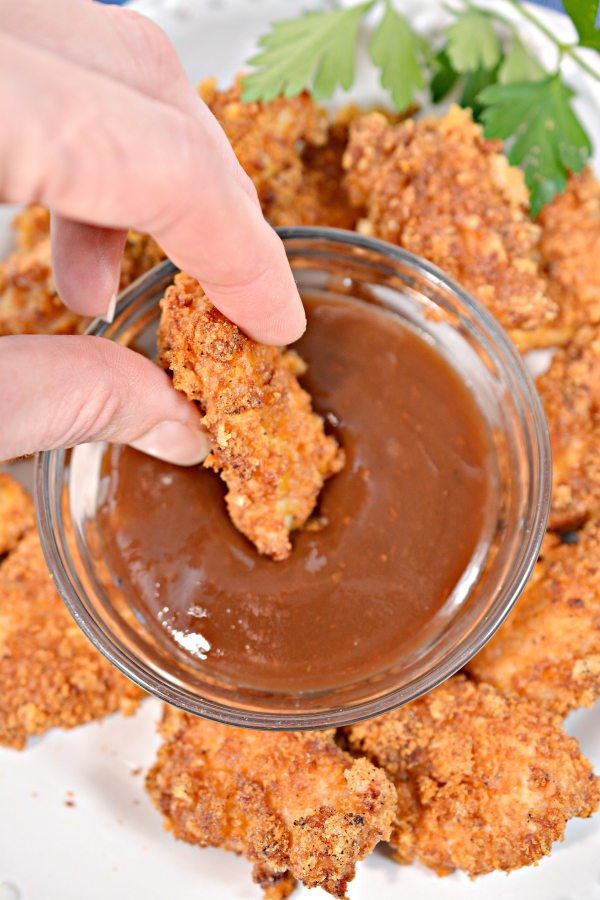 dipping a keto chicken nugget in sauce