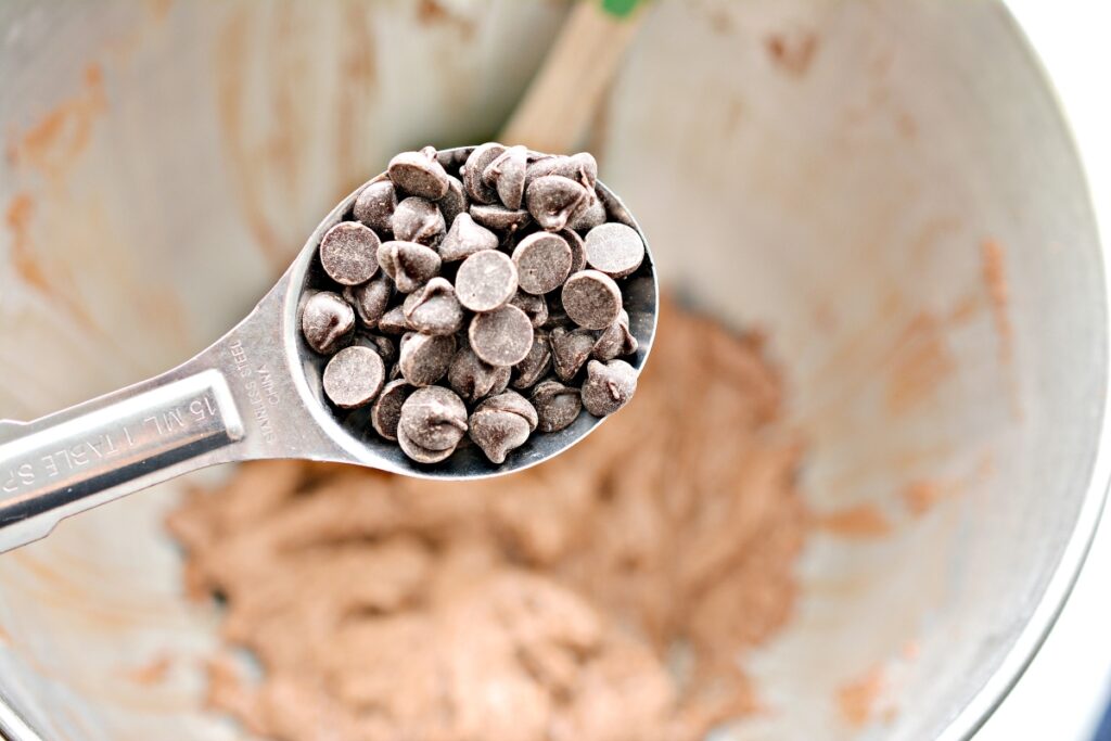 spoon of sugar free chocolate chips over the mixing bowl