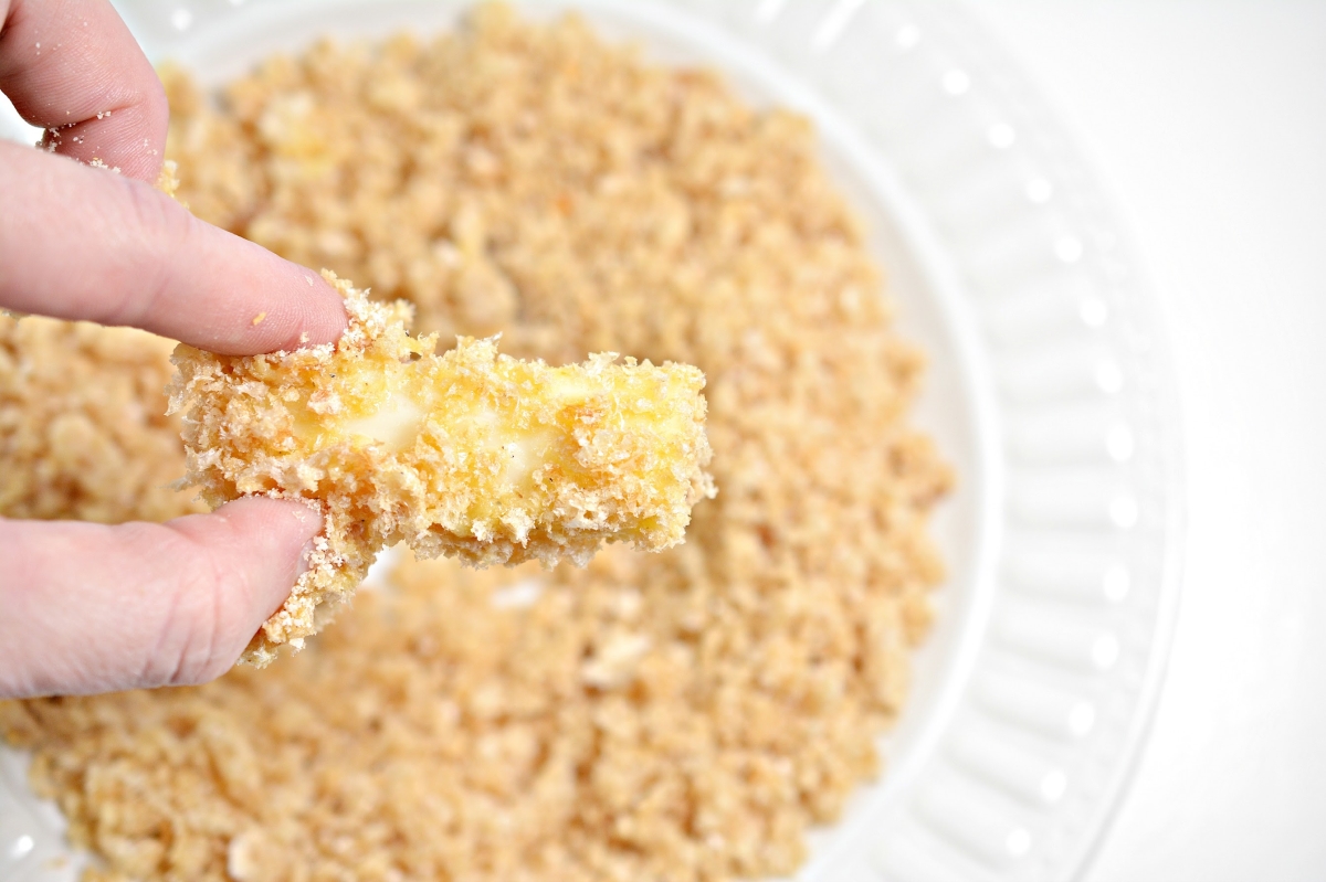 adding pork rind crumbs to the cheese stick