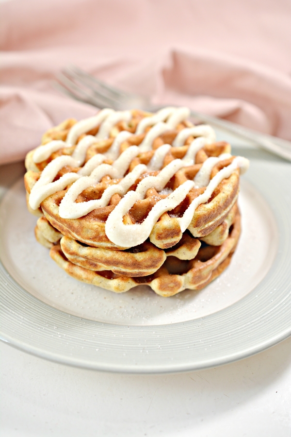 three cinnamon roll chaffles stacked up together on a plate