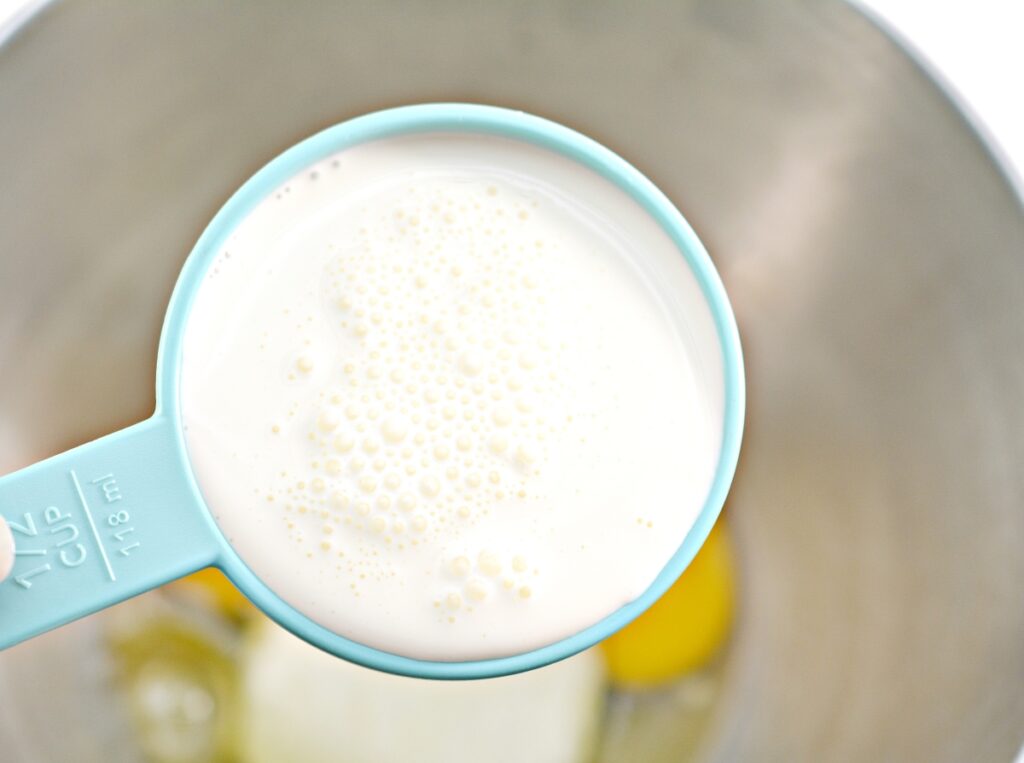 heavy cream in a measuring cup over a mixing bowl