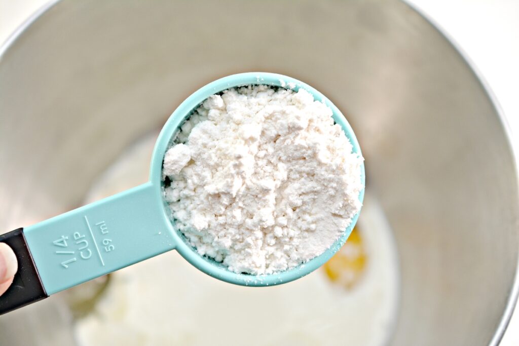 sweetener in measuring spoon over mixing bowl