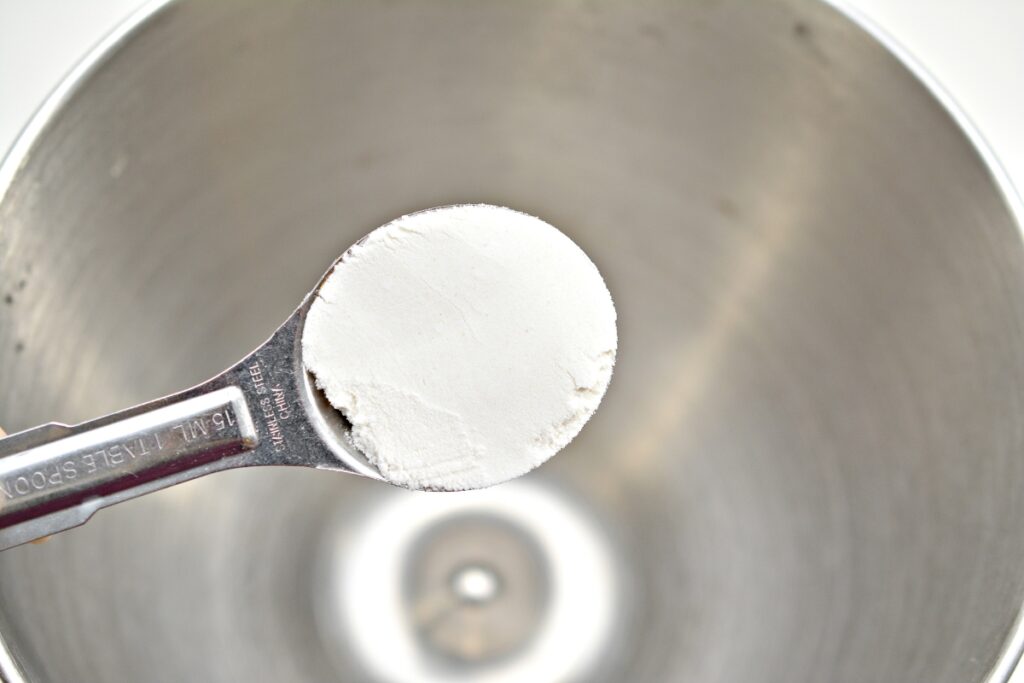 baking powder in a teaspoon over a mixing bowl