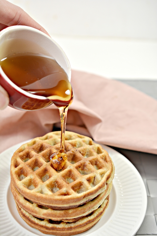 maple syrup being poured onto chaffles 