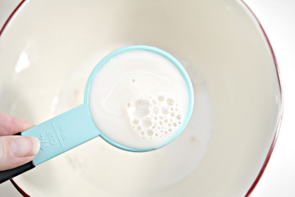 1/4 cup of almond milk over a mixing bowl 