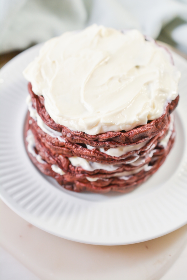 close up view of the cream cheese frosting on top of red Velvet Chaffles on a plate