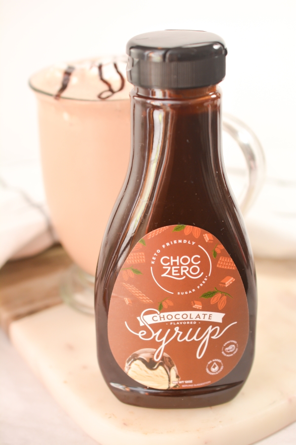 choczero chocolate syrup bottle in front with keto milkshake in the background