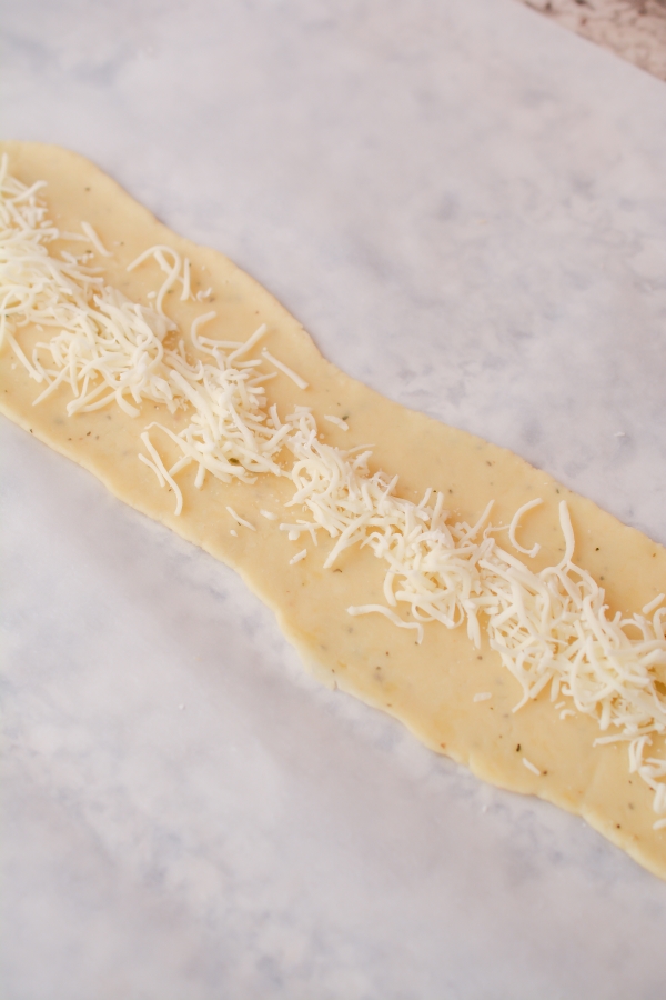 shredded cheese on flatten dough