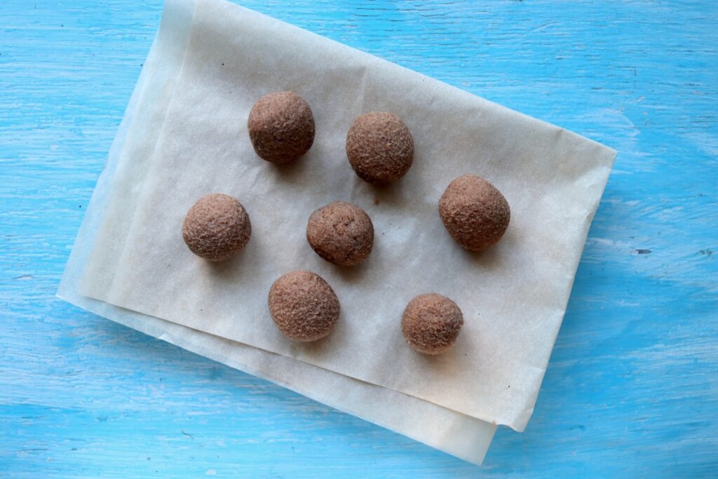 rolled up peanut butter balls on parchment paper