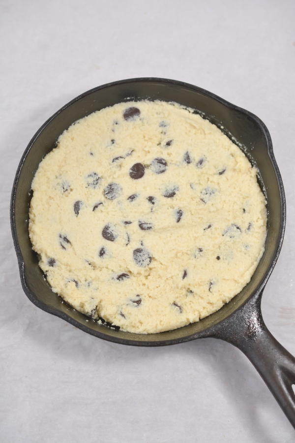 cookie dough being pressed into skillet